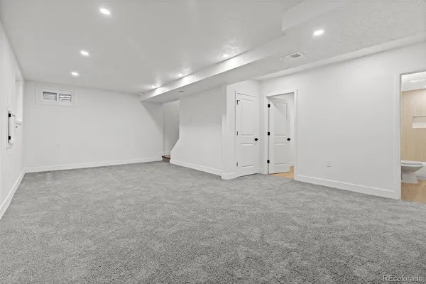 an empty room with closet and windows
