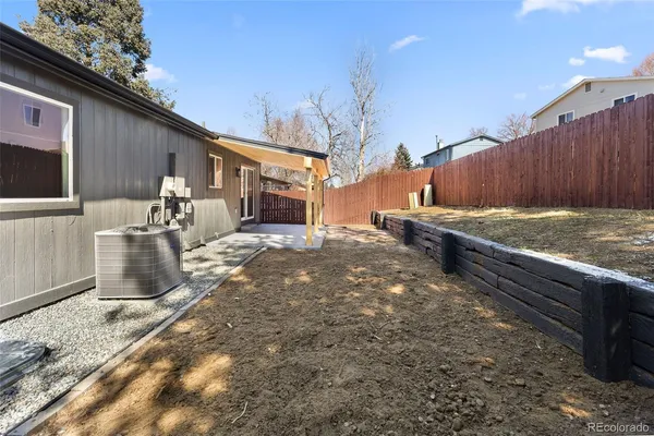a view of a backyard with table and chairs with wooden fence