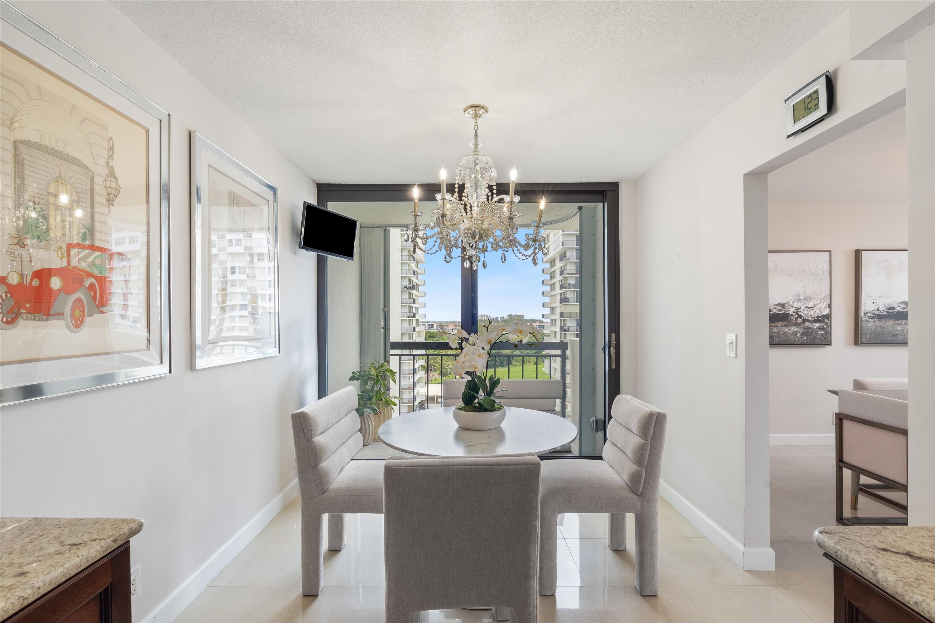 2003 North Ocean Boulevard, Unit 902 Boca Raton, FL 33431 - Photo 12 of 45 a dining room with furniture a chandelier and wooden floor