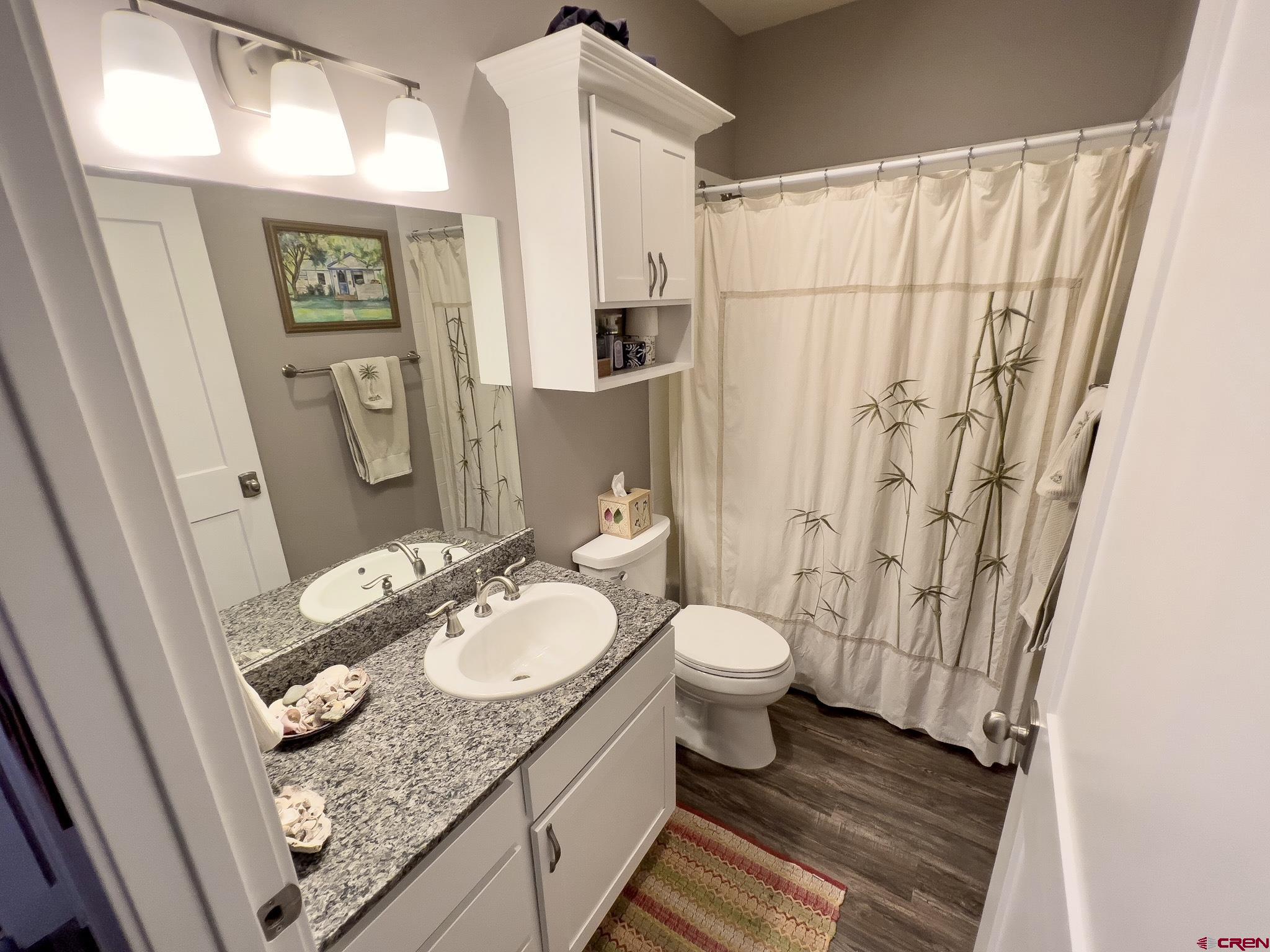 210 West 3rd Street, Unit 2 Cortez, CO 81321 - Photo 12 of 19 a bathroom with a granite countertop sink and a mirror