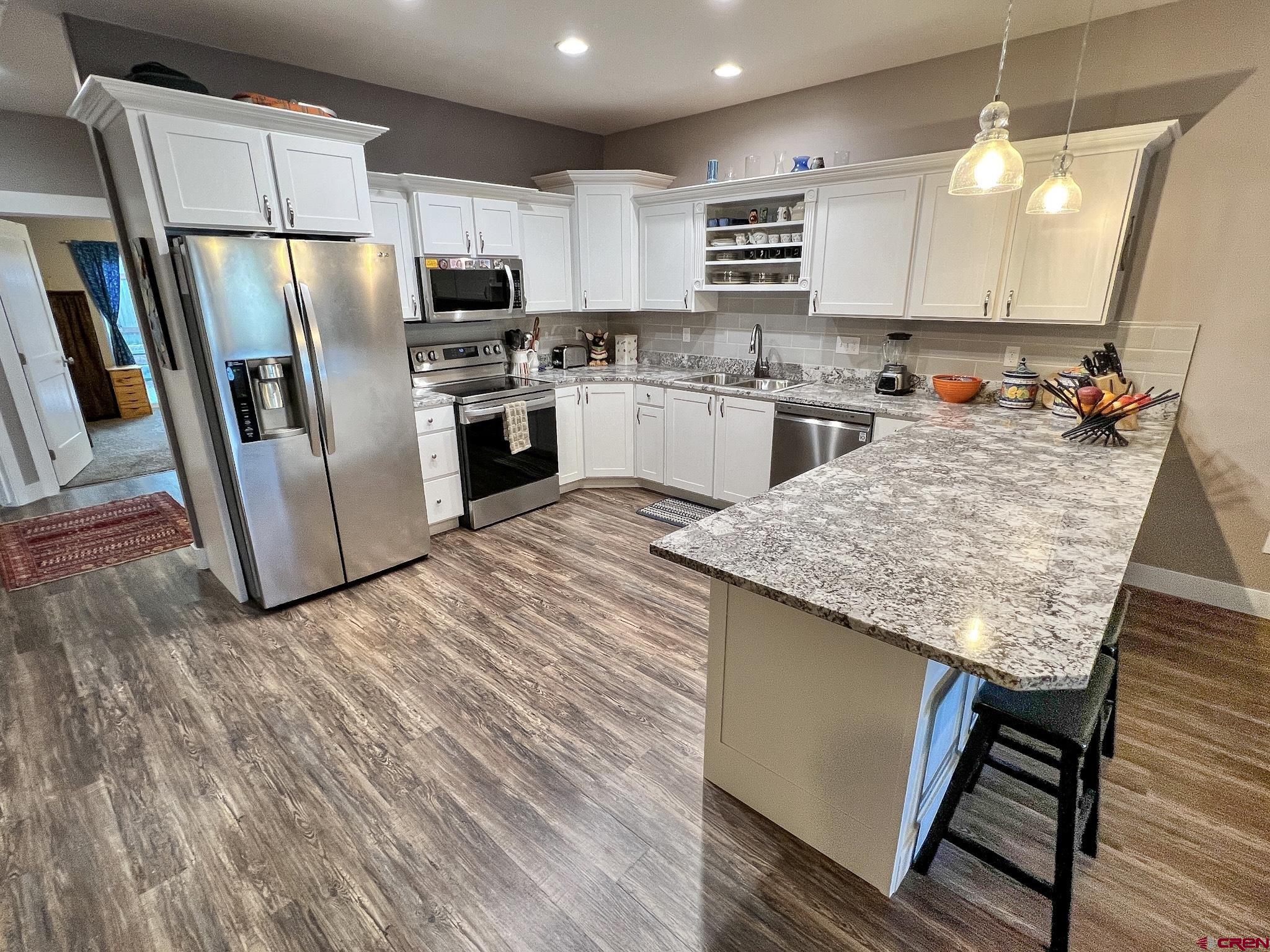 210 West 3rd Street, Unit 2 Cortez, CO 81321 - Photo 2 of 19 a kitchen with stainless steel appliances granite countertop a refrigerator sink and microwave