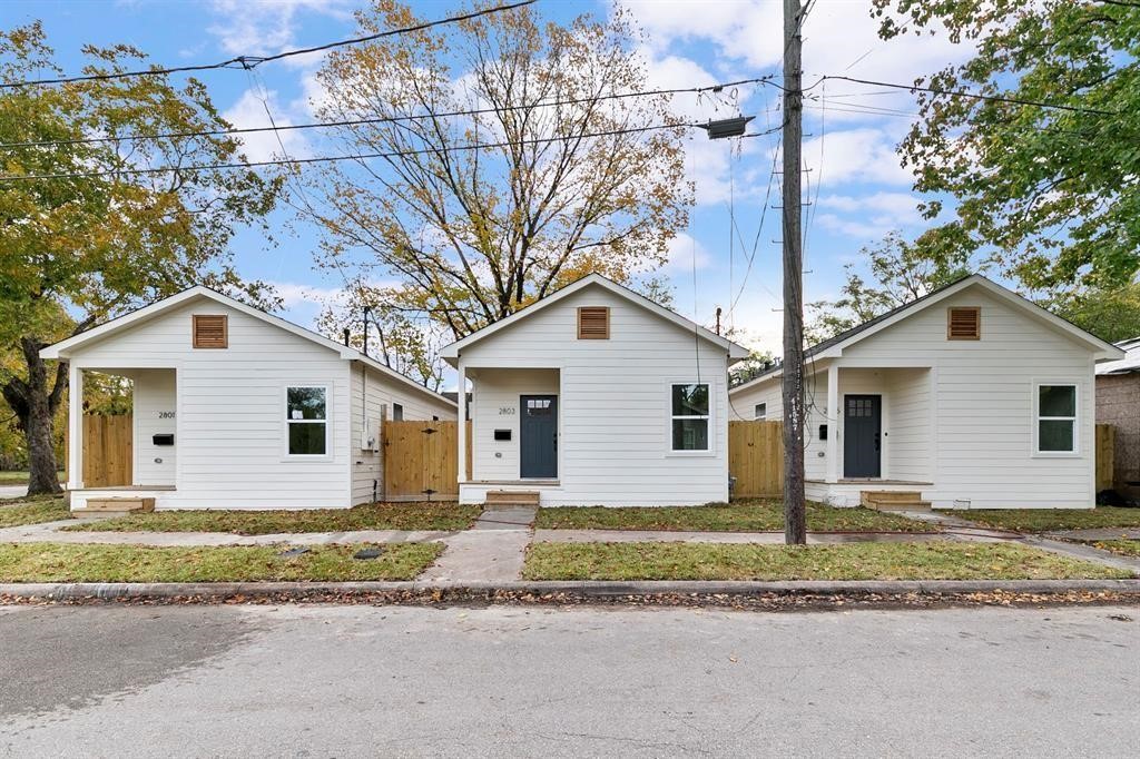 2805 Nettleton Street Houston, TX 77004 - Photo 1 of 9 This photo shows three charming, identical white bungalows with front porches, situated side by side on a quiet street. Each home features a small front yard and simple landscaping, with a clean, modern design.