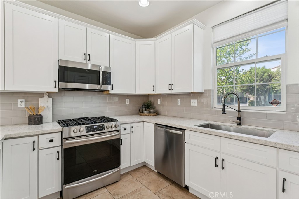 4155 Windspring Street Corona, CA 92883 - Photo 10 of 38 a kitchen with cabinets appliances a sink and a window