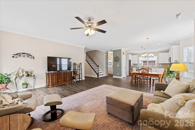a living room with furniture kitchen view and a chandelier