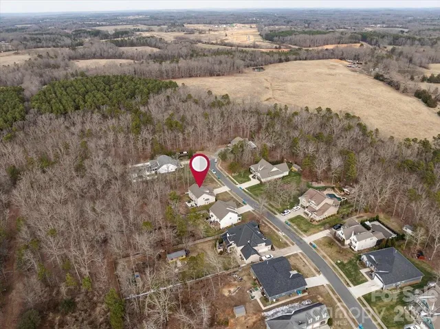an aerial view of a red yard with wooden fence