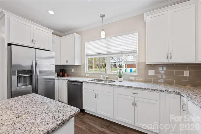 a kitchen with granite countertop white cabinets and white appliances