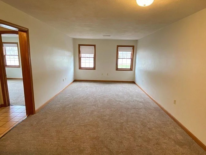 132 Tyngsboro Road, Unit 1 North Chelmsford, MA 01863 - Photo 5 of 16 an empty room with windows