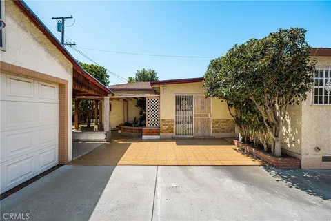 a view of a house with backyard and a tree