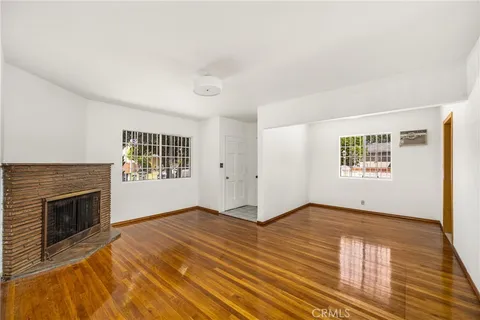 an empty room with windows and fireplace