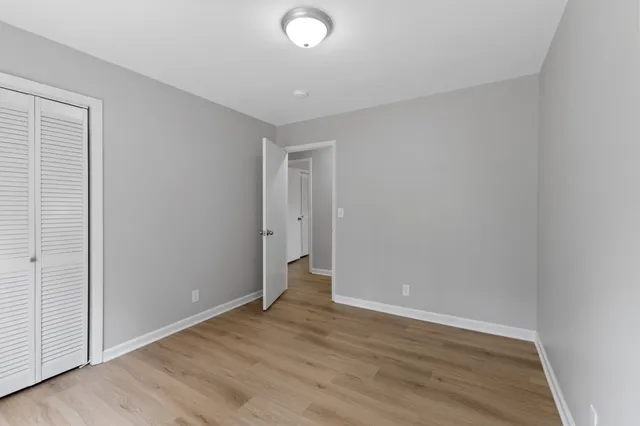 a view of an empty room with wooden floor