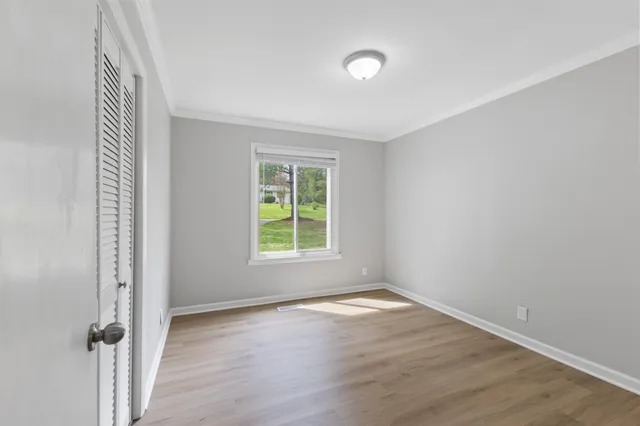an empty room with wooden floor and a window
