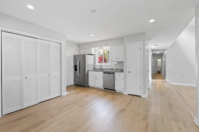 a view of a kitchen with refrigerator and wooden floor