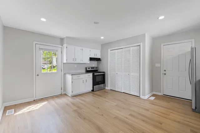 a kitchen with a refrigerator and a stove top oven