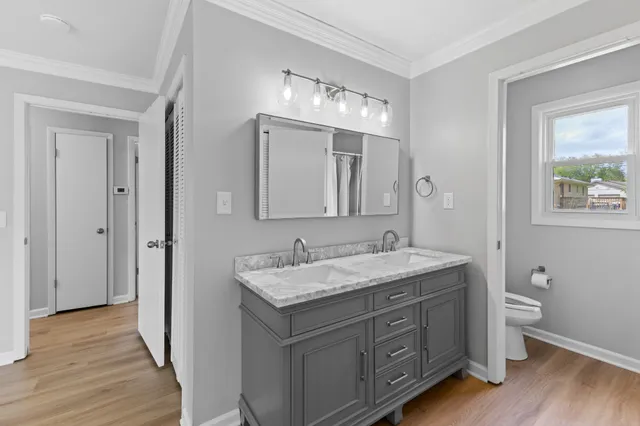 a bathroom with a granite countertop toilet sink and mirror