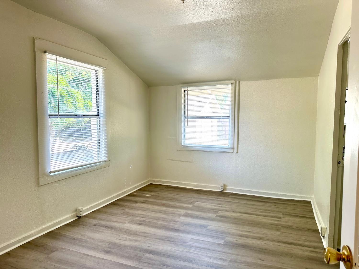 809 Washington Avenue Madera, CA 93638 - Photo 11 of 20 an empty room with wooden floor and windows