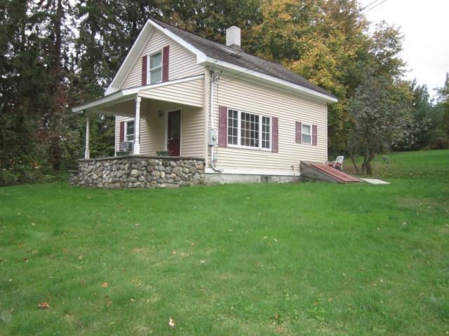 a view of a house with a yard and sitting area