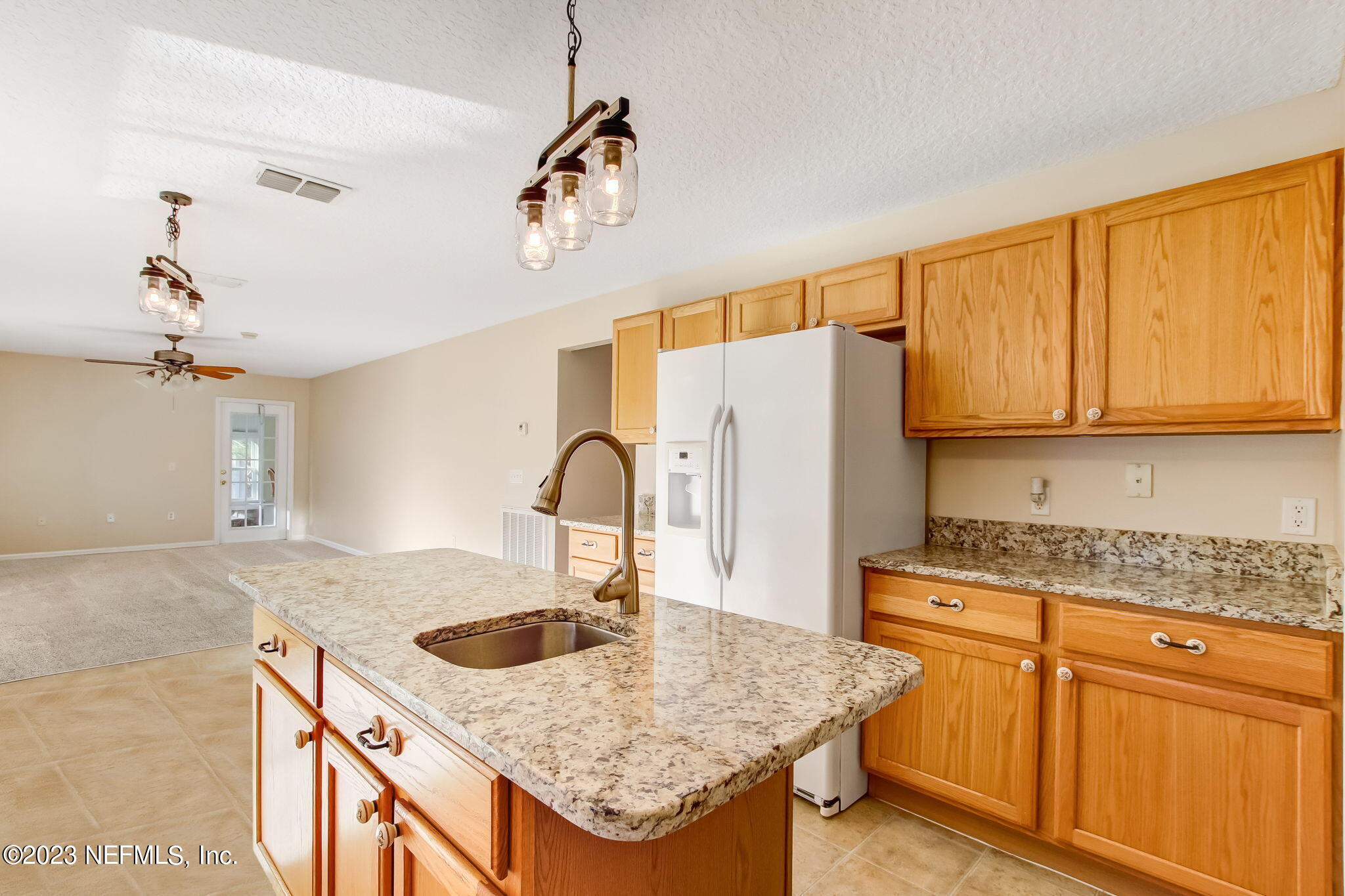 54005 Turning Leaf Drive Callahan, FL 32011 - Photo 15 of 54 a kitchen with stainless steel appliances granite countertop a sink dishwasher and refrigerator with wooden cabinets