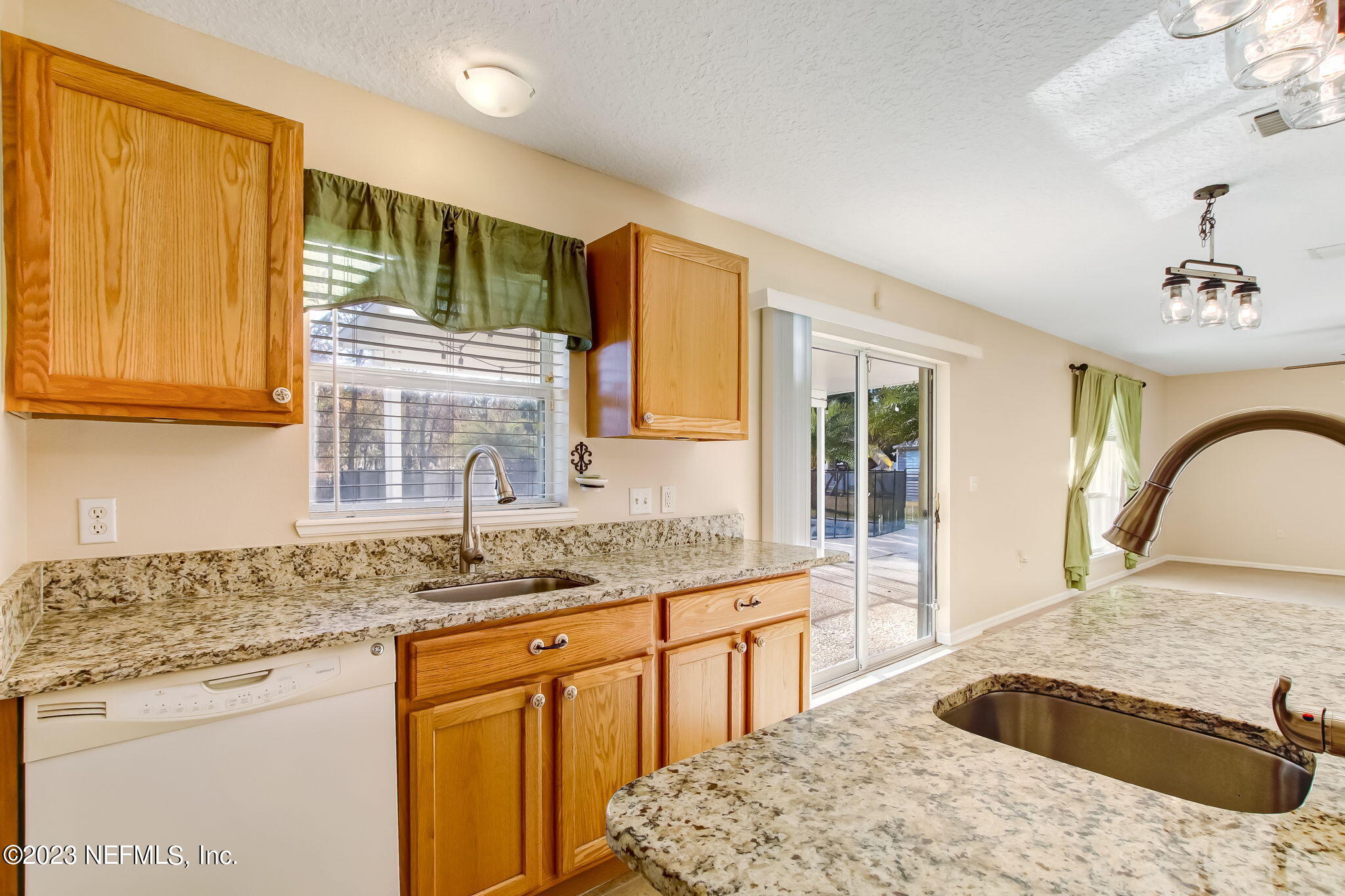 54005 Turning Leaf Drive Callahan, FL 32011 - Photo 16 of 54 a kitchen with granite countertop a sink stainless steel appliances and cabinets