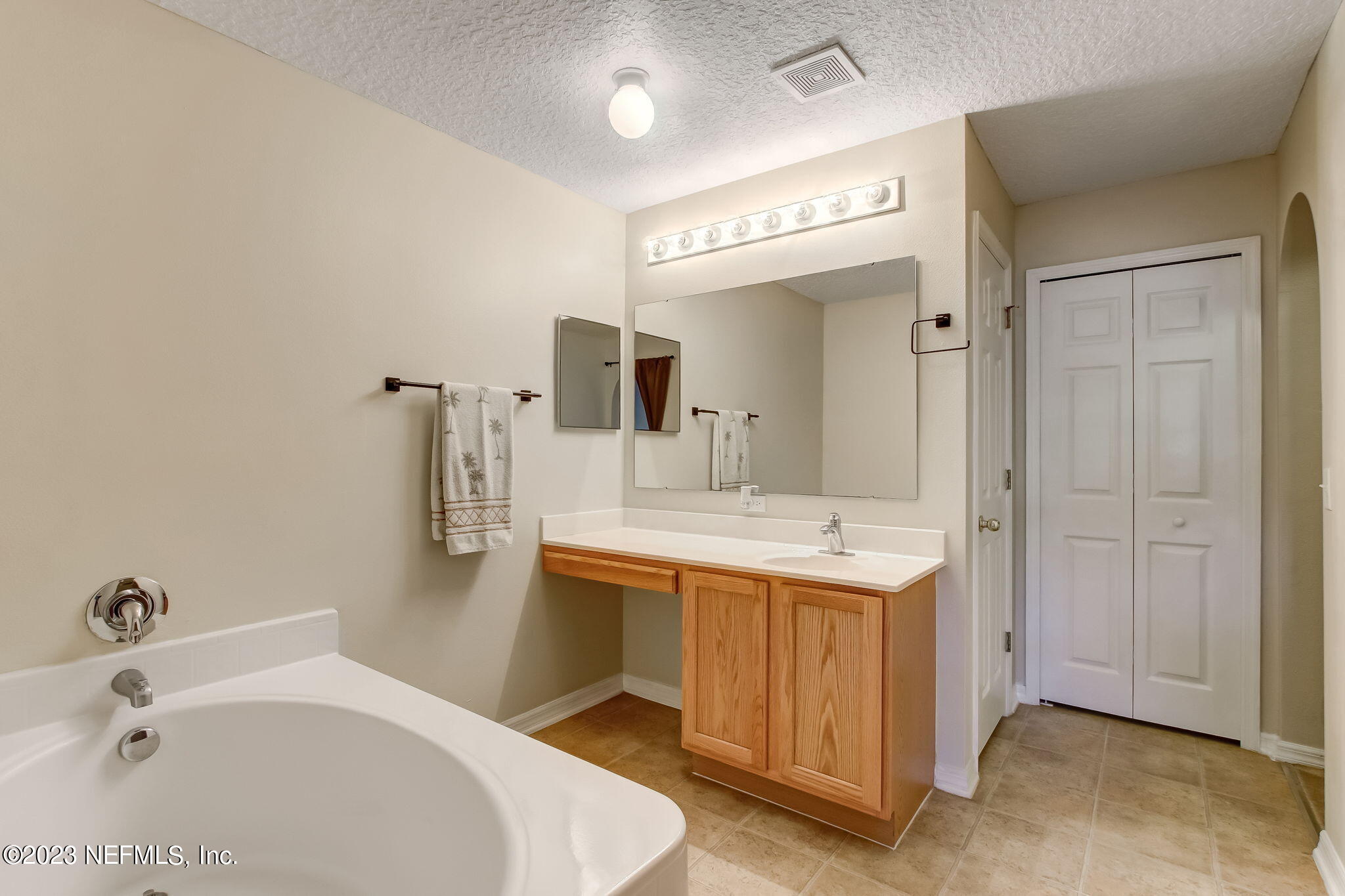 54005 Turning Leaf Drive Callahan, FL 32011 - Photo 26 of 54 a bathroom with a tub sink and mirror