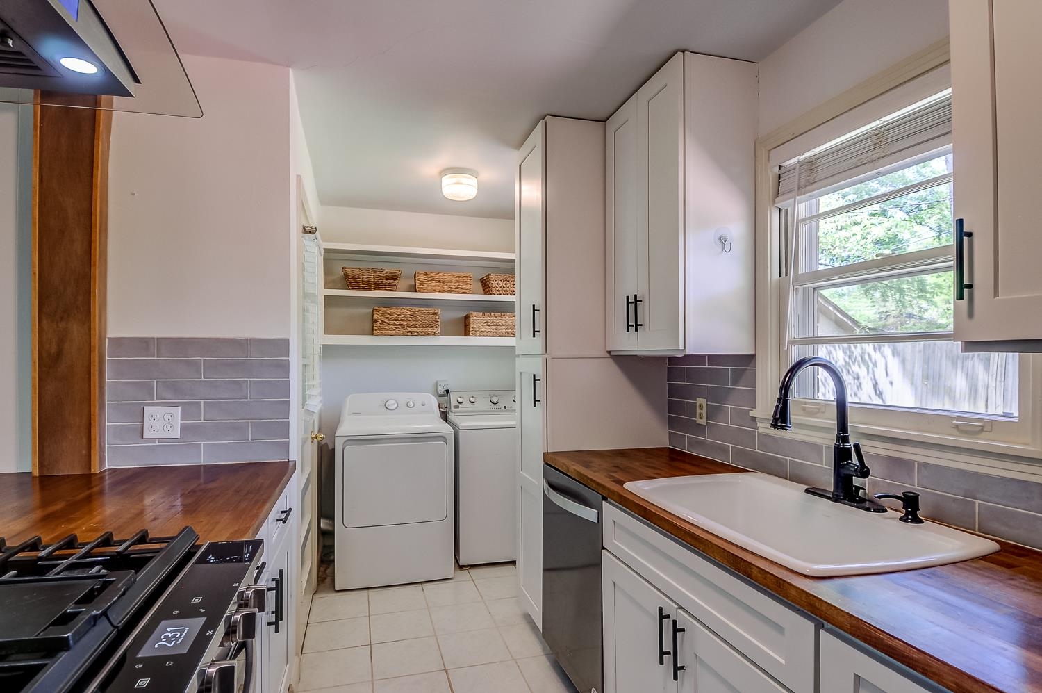5056 Wingdale Road Memphis, TN 38117 - Photo 12 of 18 Kitchen with wood counters, stainless steel appliances, washer and dryer, and white cabinets