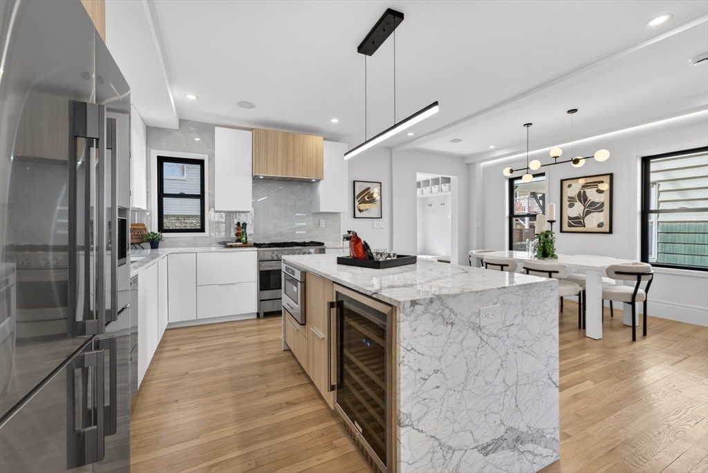 29 Line Street Cambridge, MA 02138 - Photo 12 of 42 a kitchen with white cabinets appliances and wooden floor