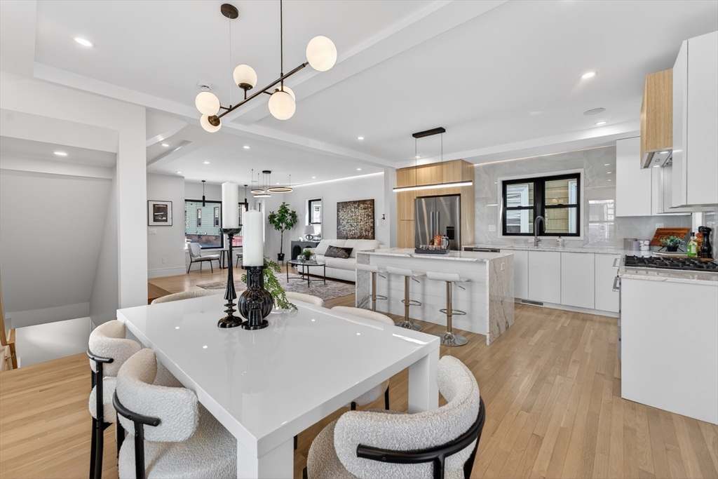 29 Line Street Cambridge, MA 02138 - Photo 21 of 42 a kitchen with a dining table chairs stainless steel appliances and cabinets