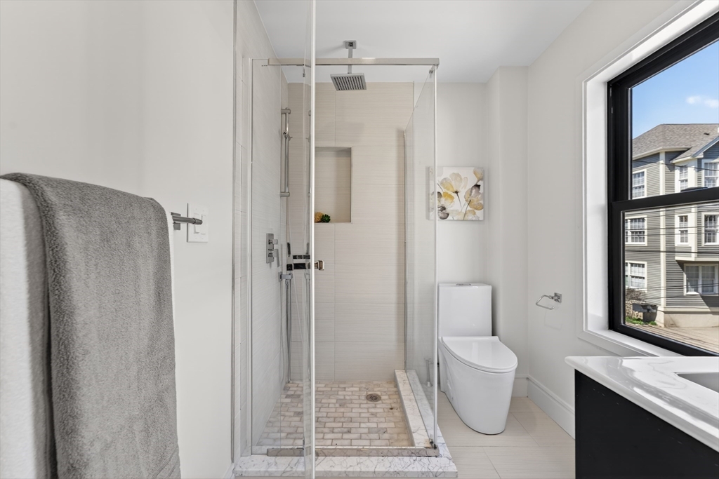 29 Line Street Cambridge, MA 02138 - Photo 36 of 42 a bathroom with a granite countertop shower a toilet and a sink