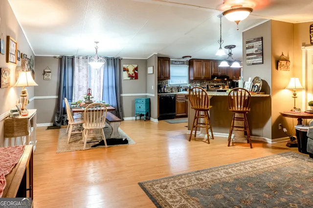 a living room with furniture a flat screen tv and kitchen view