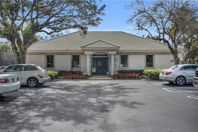 a front view of a building with a garden and fountain