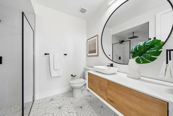 a bathroom with a granite countertop toilet a sink and a mirror