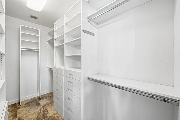 a view of walk in closet with empty racks