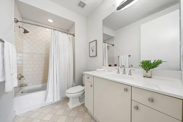 a bathroom with a granite countertop sink a toilet a mirror a vanity a shower and vanity