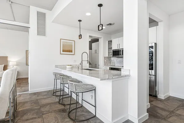 a kitchen with stainless steel appliances granite countertop a sink and a refrigerator