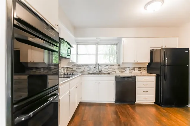 a kitchen with granite countertop cabinets appliances and a window