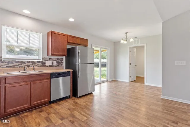 a kitchen with stainless steel appliances granite countertop a refrigerator and a sink