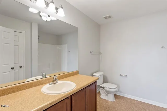 a bathroom with a sink vanity granite and toilet