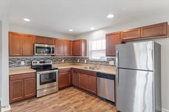a kitchen with granite countertop stainless steel appliances and wooden cabinets