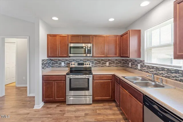 a kitchen with stainless steel appliances granite countertop a sink stove and microwave