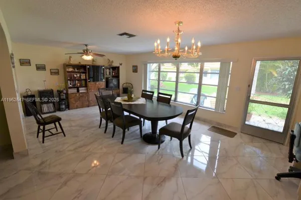 a view of a dining room with furniture and chandelier