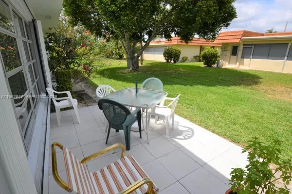 a view of a patio with table and chairs and potted plants with wooden floor and fence