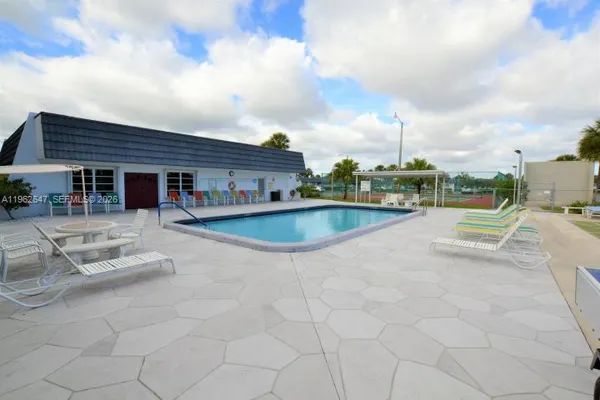 a swimming pool with outdoor seating and barbeque oven