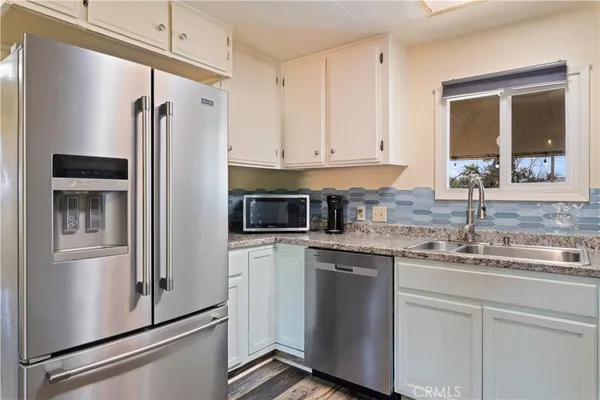 a kitchen with granite countertop a stove sink and cabinets