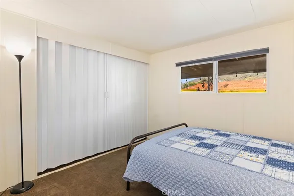 a bed sitting in a bedroom next to a window