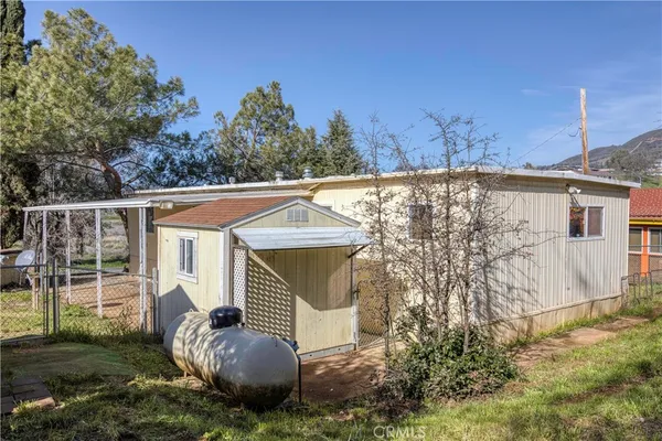 a view of house with backyard and trees