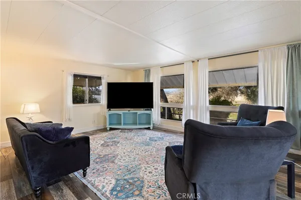 a living room with furniture a flat screen tv and a fireplace