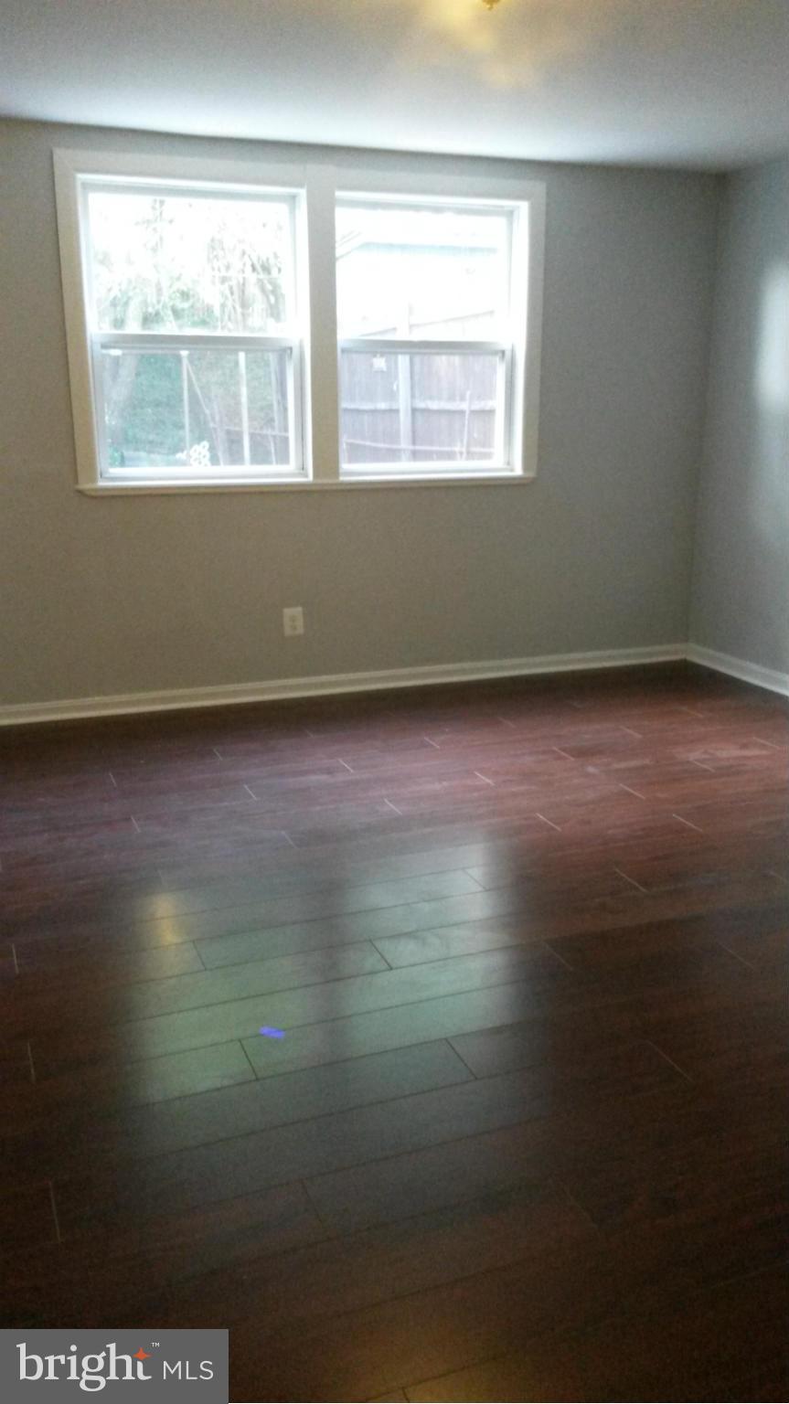 3304 Bero Road Baltimore, MD 21227 - Photo 11 of 27 an empty room with wooden floor and windows