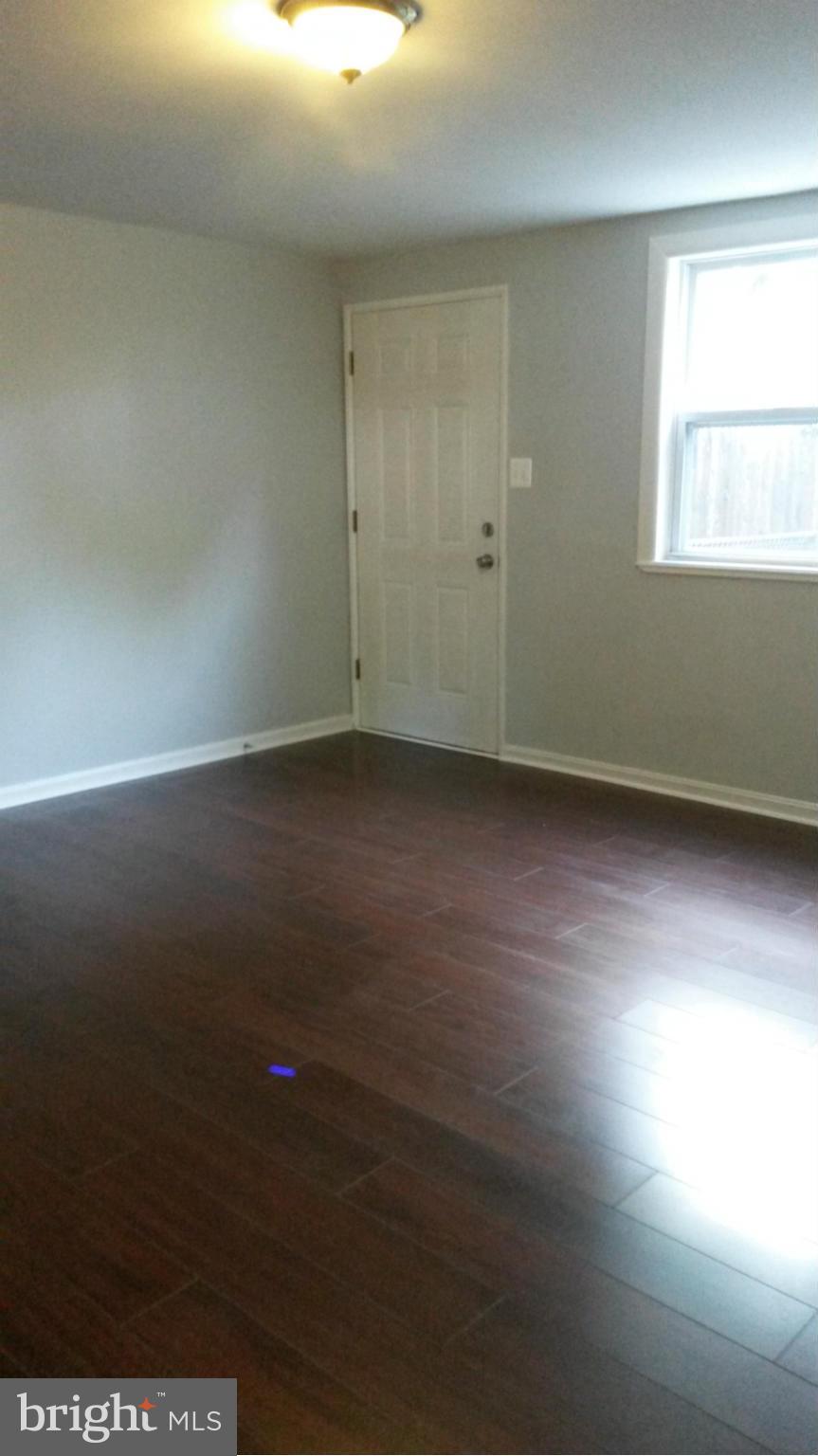 3304 Bero Road Baltimore, MD 21227 - Photo 12 of 27 an empty room with wooden floor and windows