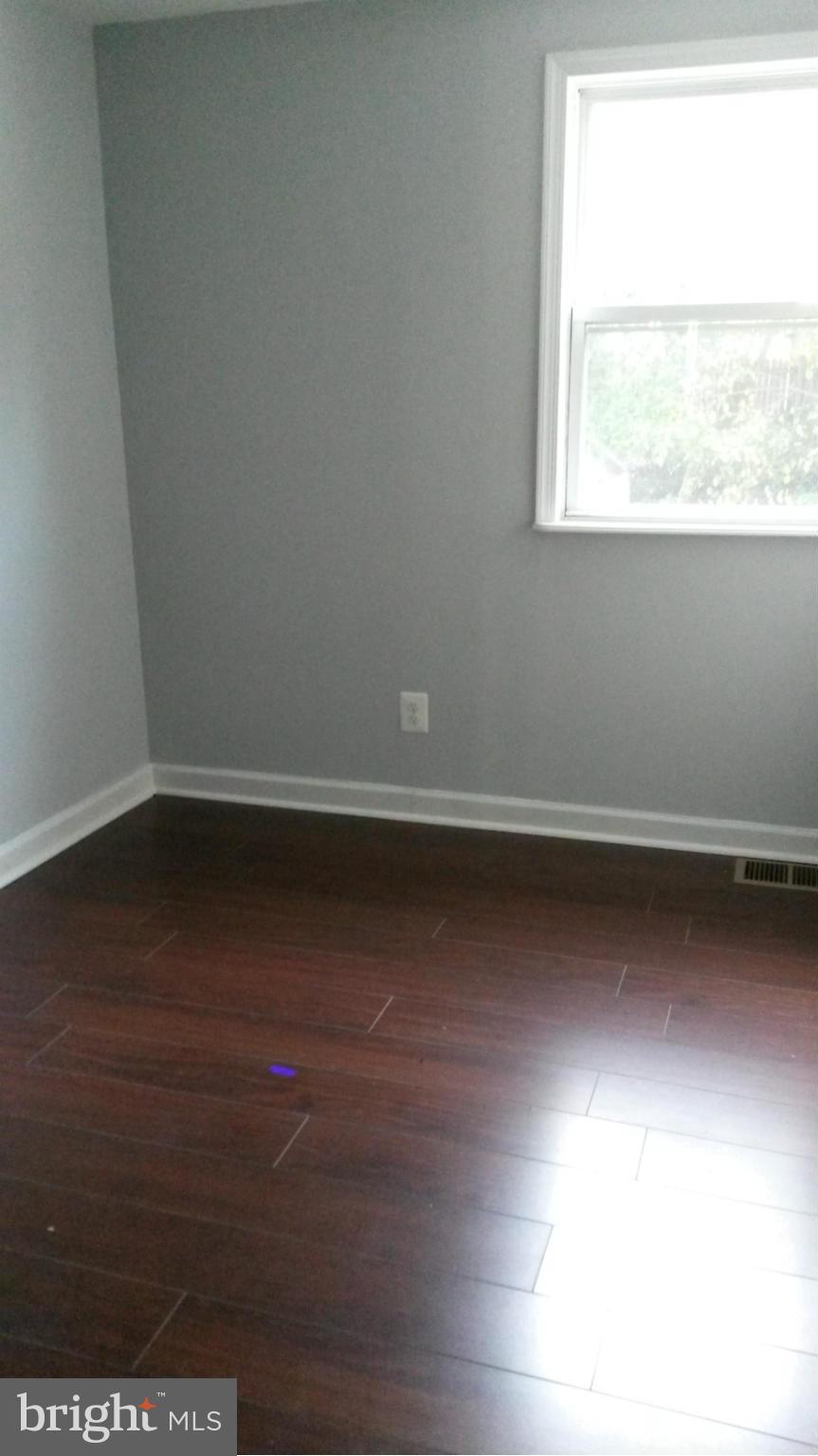 3304 Bero Road Baltimore, MD 21227 - Photo 25 of 27 an empty room with wooden floor and windows