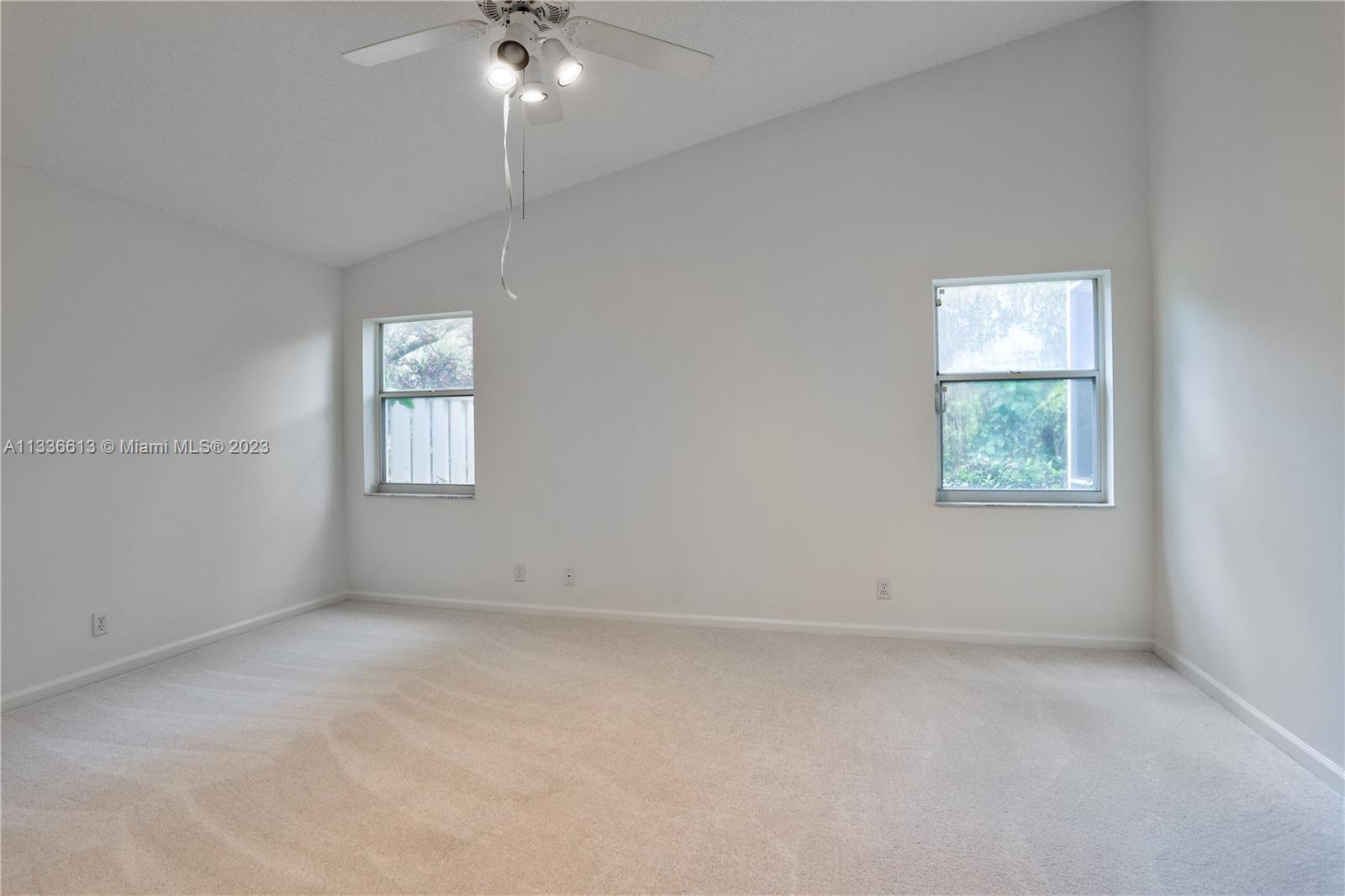 9650 Harbour Lake Circle Boynton Beach, FL 33437 - Photo 15 of 37 an empty room with windows and chandelier fan
