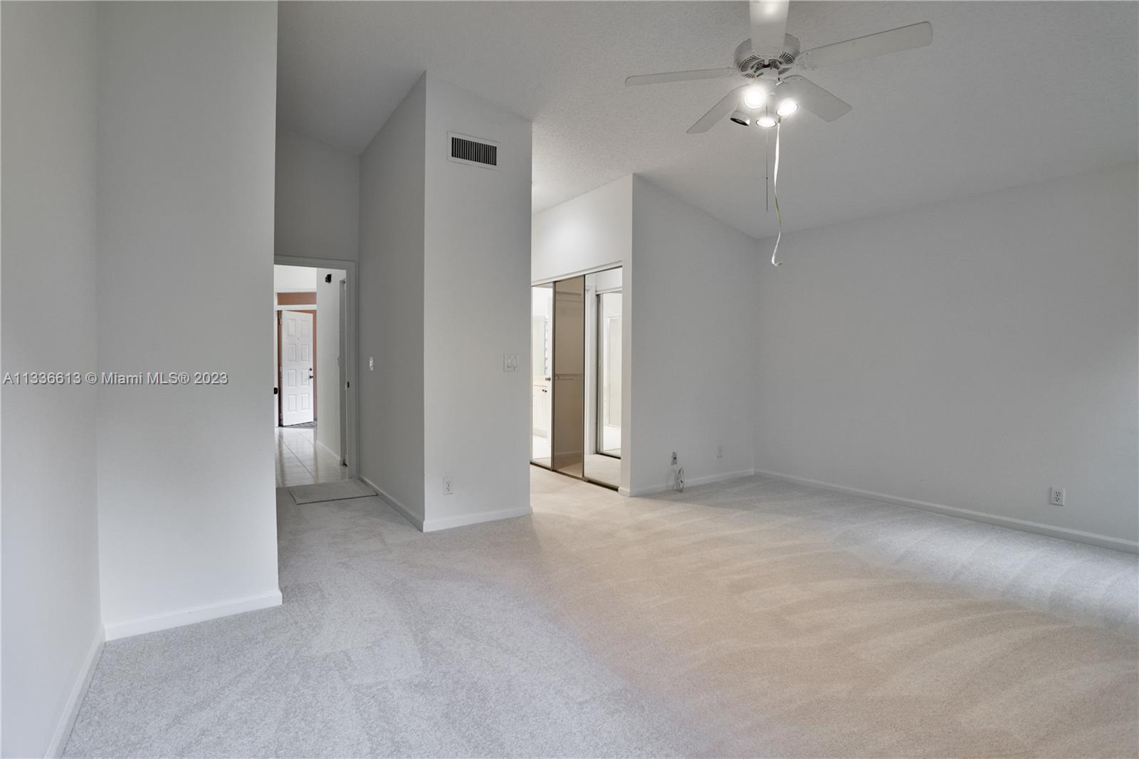 9650 Harbour Lake Circle Boynton Beach, FL 33437 - Photo 16 of 37 an empty room with chandelier fan and kitchen view